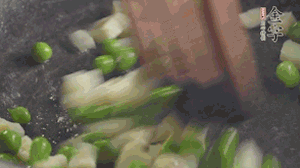 鍋中油7成熱時，入青豆、筍丁翻炒，然后加糯米飯加鹽均勻翻炒。