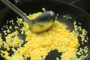 大火加熱炒鍋，再入油，燒到四至五成熱時倒入雞蛋液，在未凝結(jié)之前，加米飯煸炒，不停翻炒并用鍋鏟將成塊的米飯碾開、撥散。