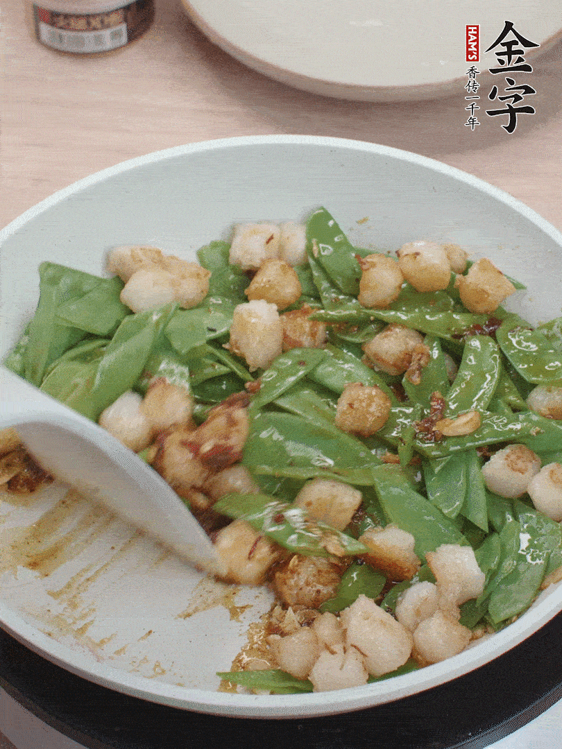 下甜豆莢、鮮貝輕輕翻炒均勻。