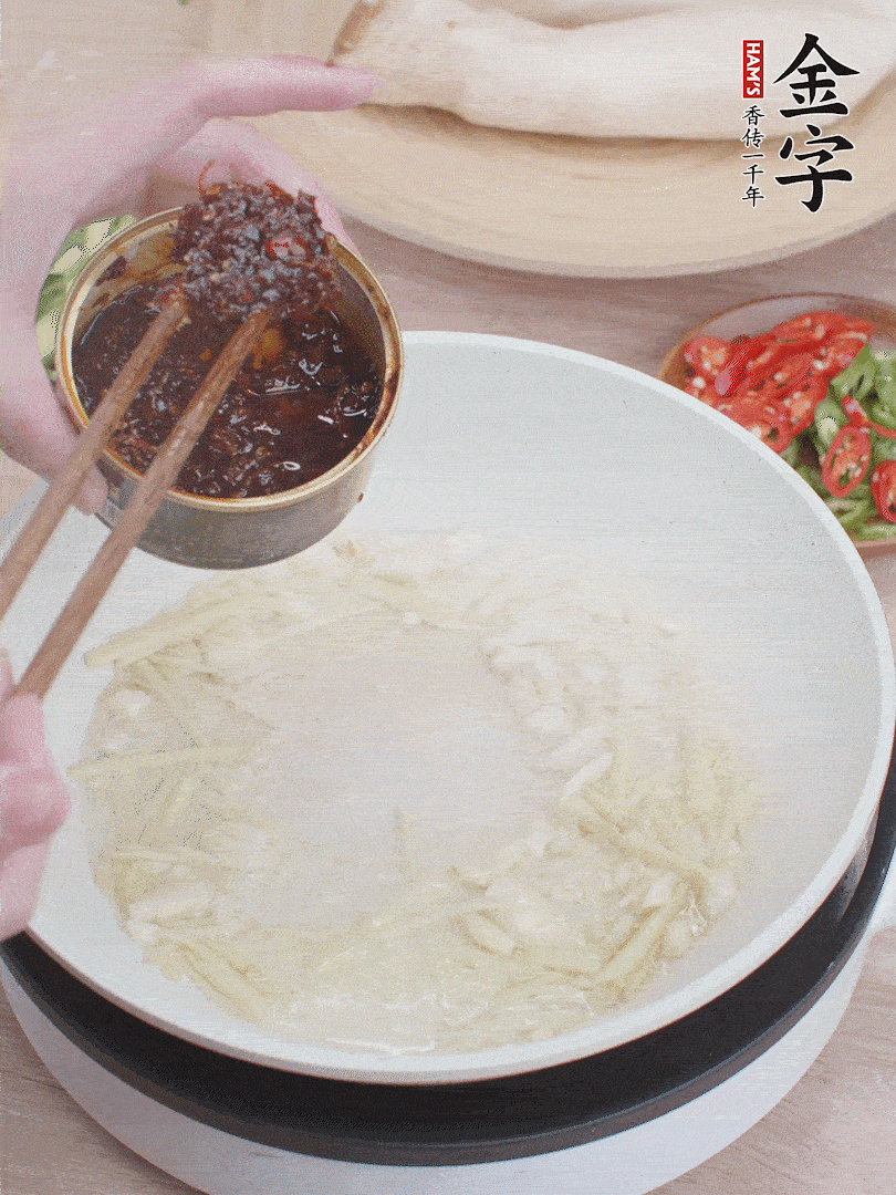 起鍋熱油，姜蒜、金字火腿干貝醬煸香。