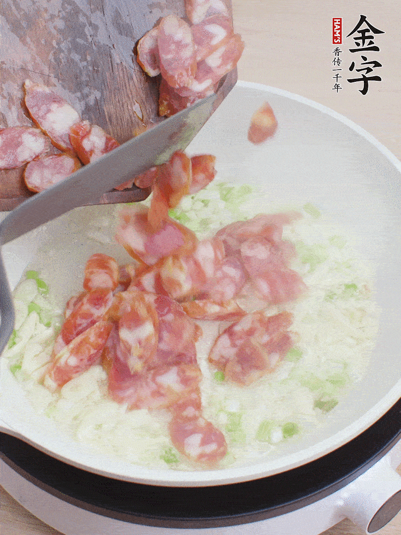 油5成熱，蒜末、蔥白爆香，下香腸炒出香味。