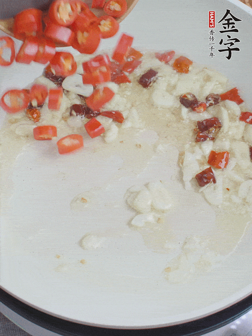 油6成熱，下蒜末、干紅辣椒煸炒，出香味后再放美人椒、香腸。