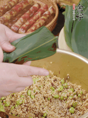 粽葉往下折，完全蓋住，兩側(cè)捏緊。