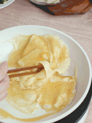 油6成熱時(shí)，下雞蛋液，邊緣凝固時(shí)翻拌成塊狀。