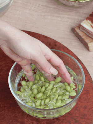 青豆剝殼，搓去外衣。