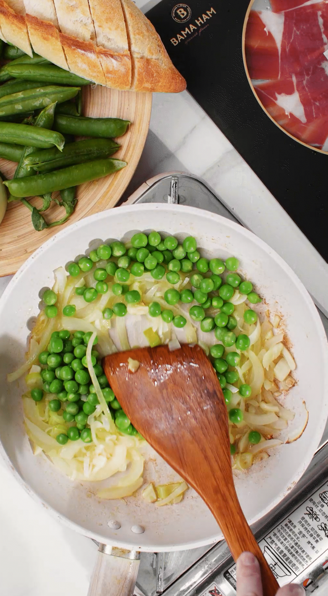 鍋中放入黃油融化，加入洋蔥絲、大蔥蔥白絲、蒜末翻炒變軟出香味。加入剛剛汆燙冰鎮(zhèn)后的豌豆，取出一點(diǎn)點(diǎn)待會(huì)擺盤(pán)裝飾用。加一點(diǎn)鹽 (和黑胡椒) 調(diào)味。